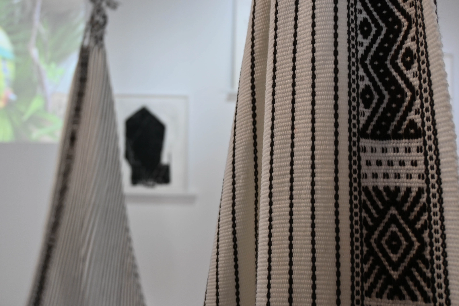 Detail of black-and-white woven hanging seats in the Magical Operations exhibition