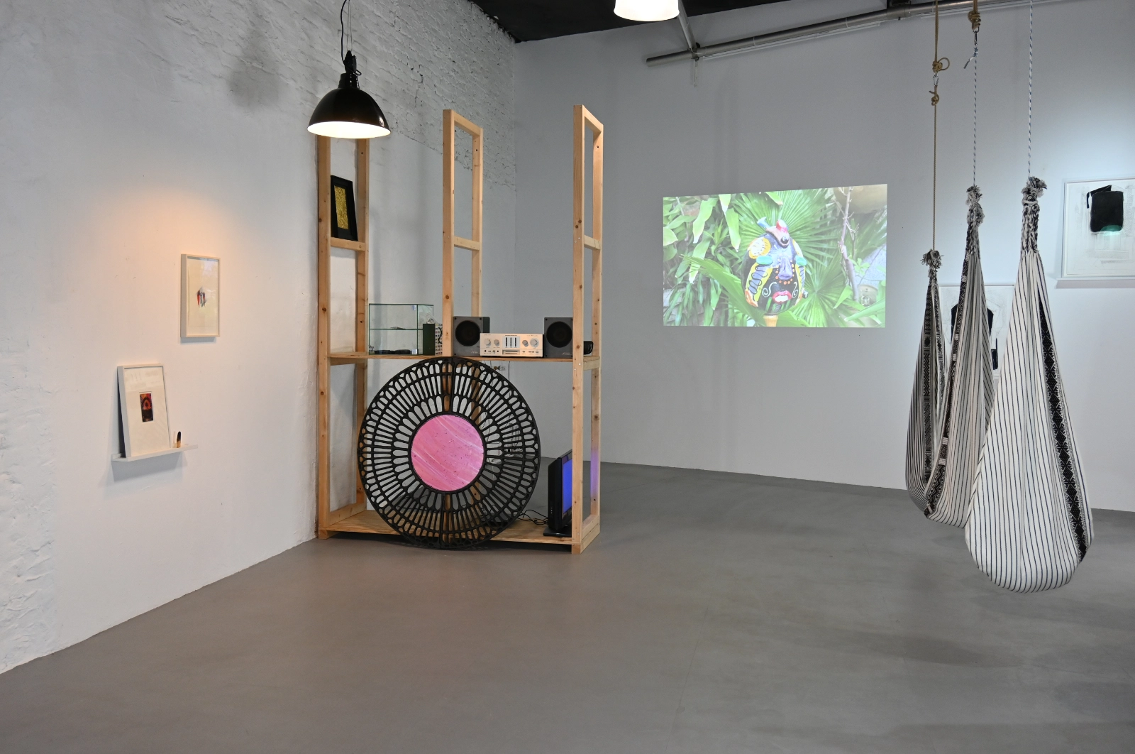 Wide Magical Operations exhibition view with video projection, sound installation and woven hanging seats