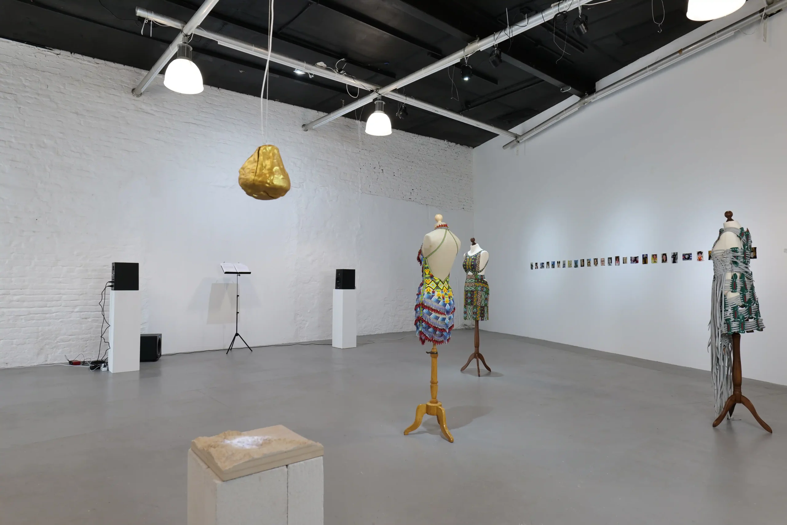 Exhibition view with sound works and garments on mannequins at Wild Palms