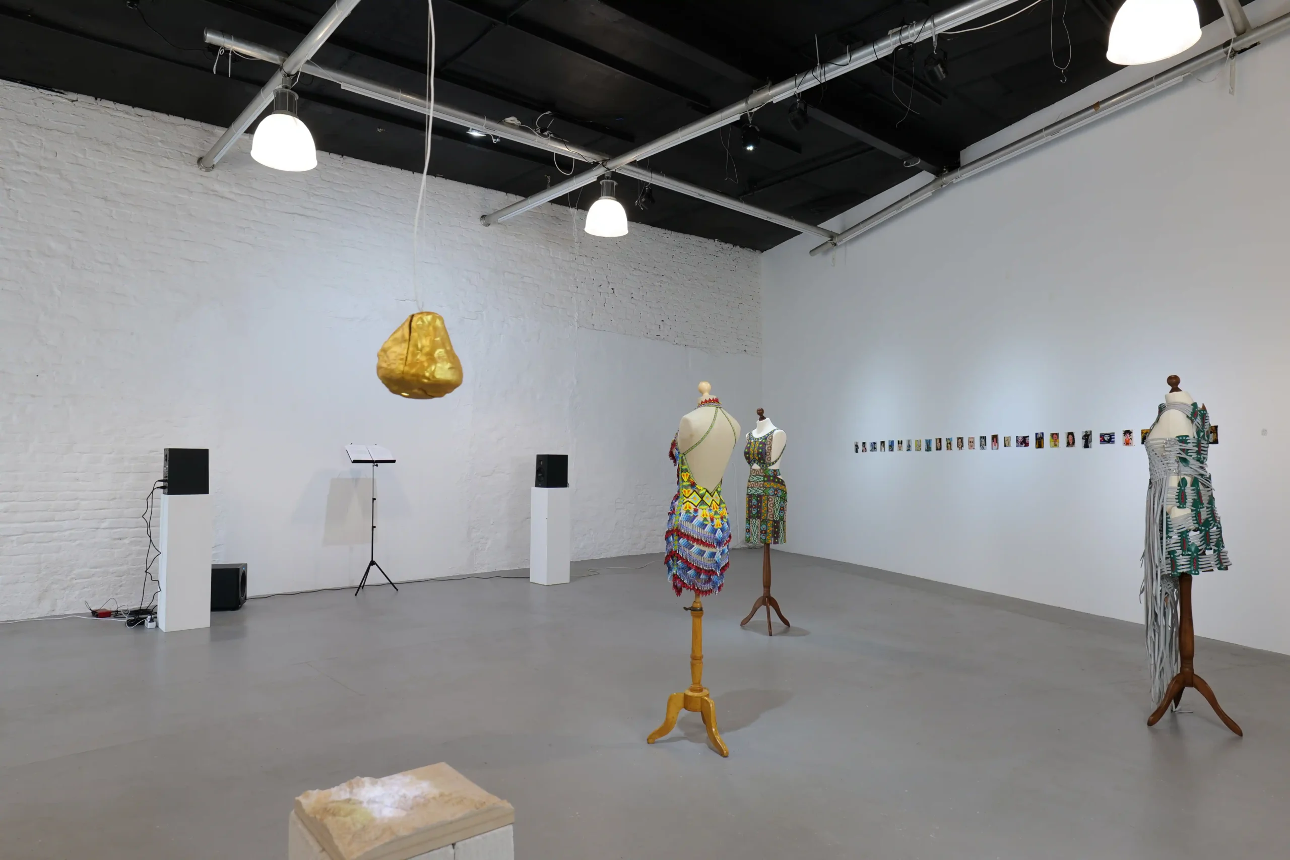 Wide exhibition view of garments, sound works and sculpture at Wild Palms