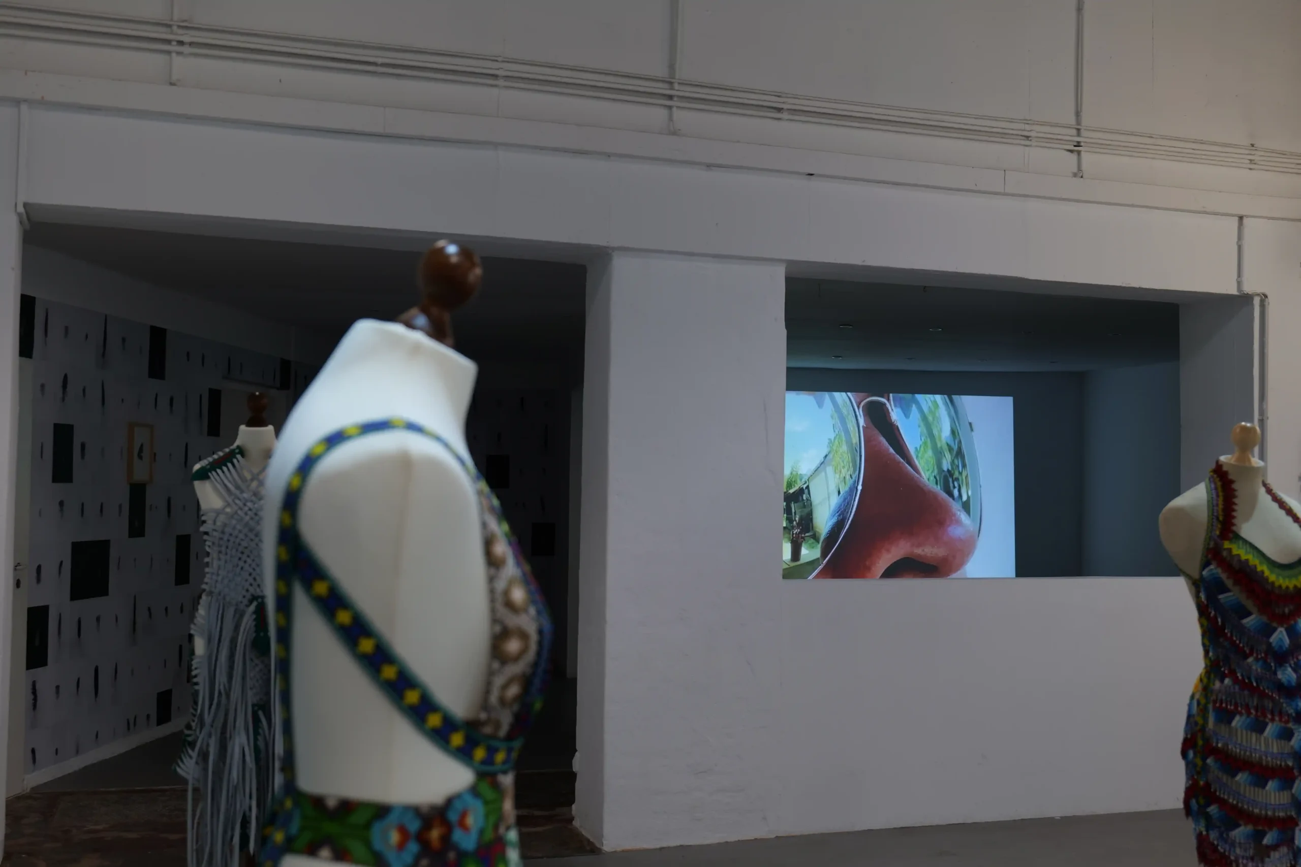 Gallery view featuring textile works and wall-based artworks