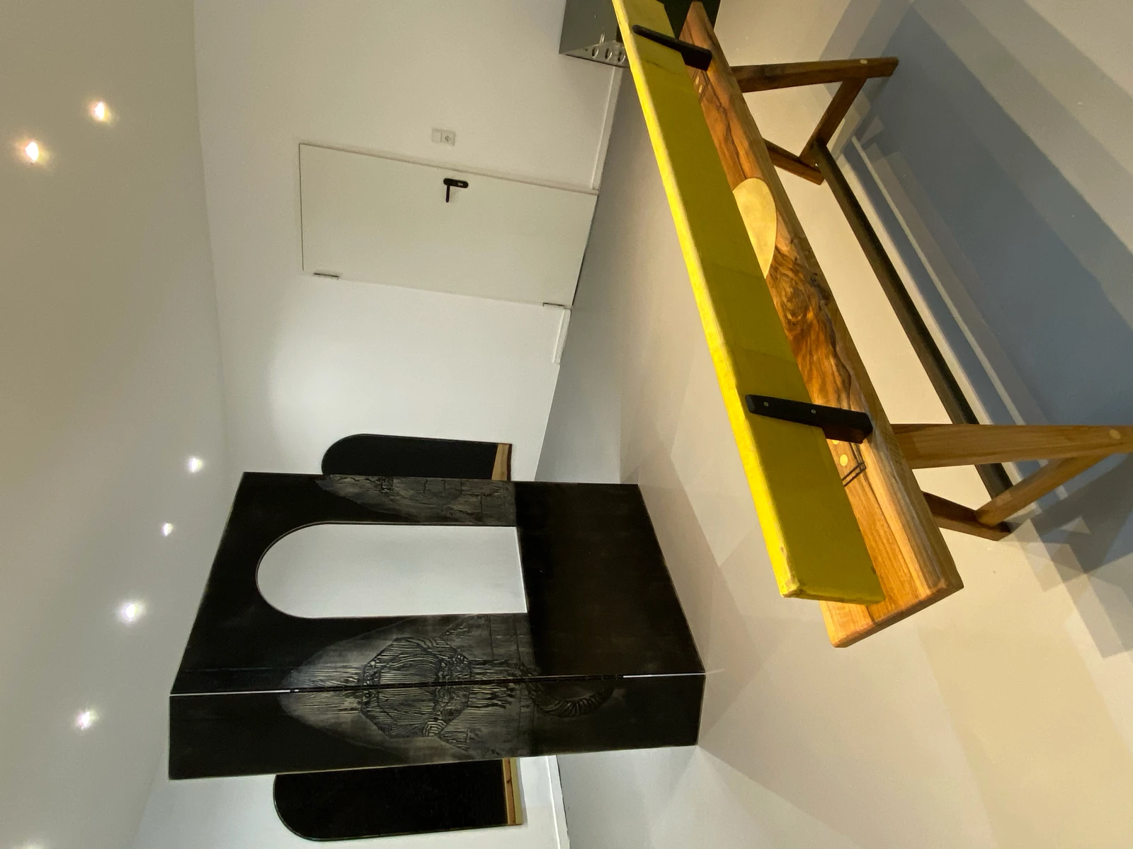 Engraved black wood work by Brunhilde Bordeaux-Groult and yellow-top wood bench by Robert Elfgen, Passage exhibition at wildpalms Düsseldorf, curated by Jorge Sanguino