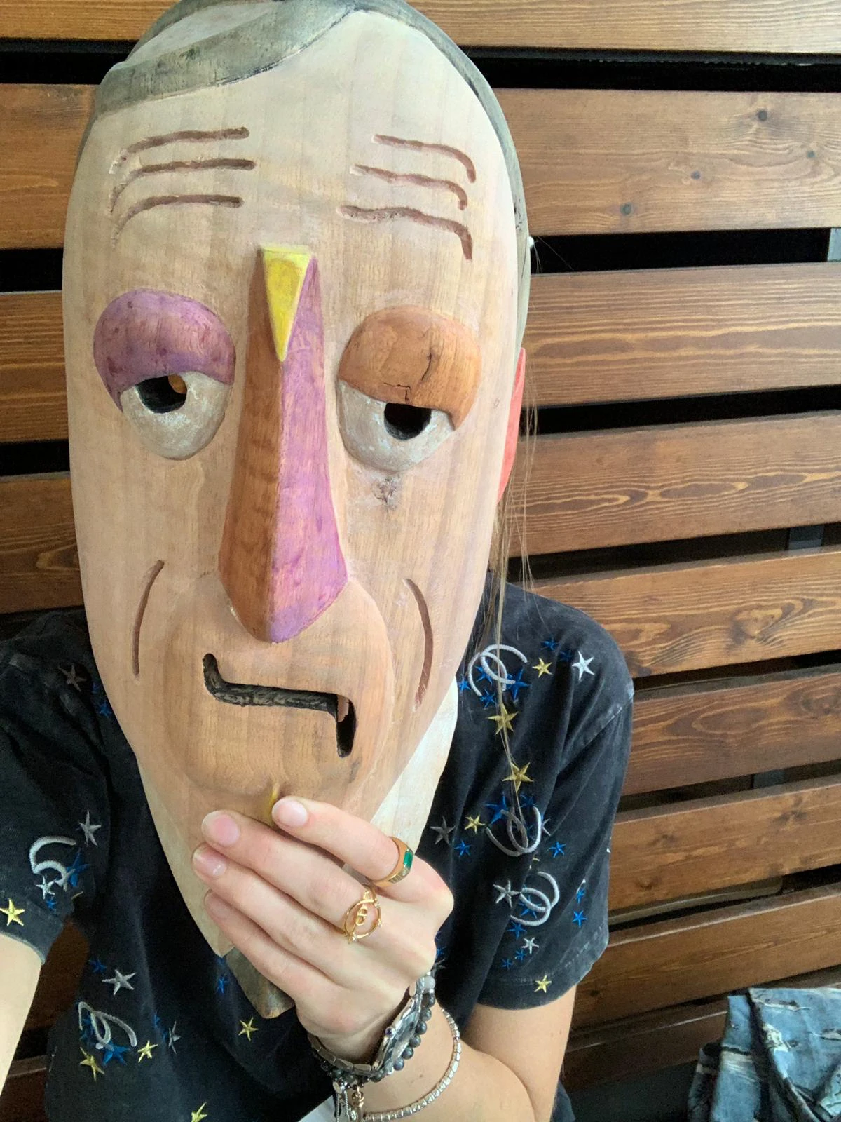 Una máscara de madera tallada sin pintar de la serie Performing White Skin de Mauricio Limón, sostenida de cerca