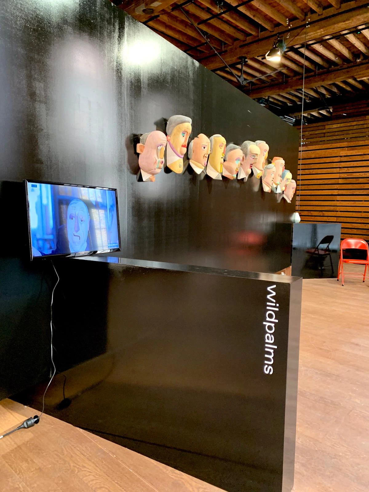 Stand de wildpalms con las máscaras de Mauricio Limón, una pantalla de video y área de asientos, POPPOSITIONS Art Fair, Bruselas