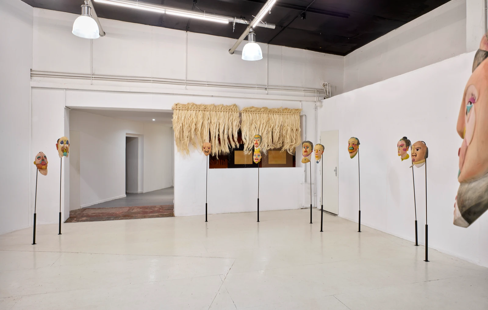Máscaras de madera pintadas de Mauricio Limón instaladas en dos salas de la galería en wildpalms